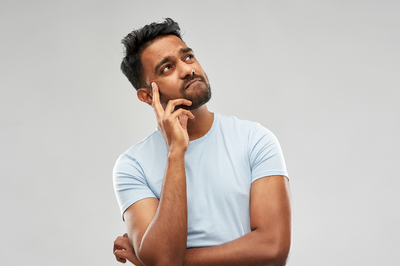 man looking up, finger on face, thinking